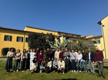 students standing outside the yellow school building in the sunshine