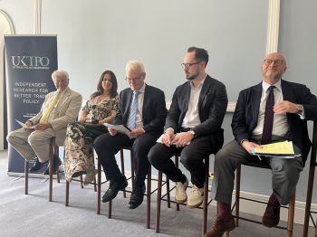 A panel of people sitting on high chairs wait to start a debate