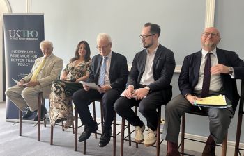 A panel of people sitting on high chairs wait to start a debate