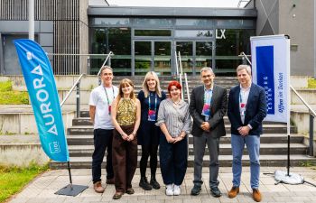 Right to Left - Cornell Sanvoss Robin Banerjee, Annie McEntee, Louise Turton, Elena Southard, Matt Montgomery, stood in front of university steps
