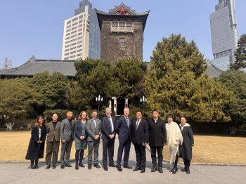 Delegates at Nanjing University standing outside in front of a university building