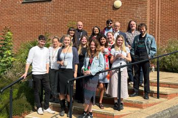 The University's Digital Team standing on the steps outside Sussex House