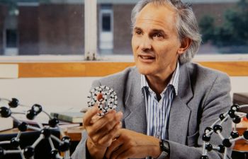 Professor Sir Harry Kroto holding a model of a buckyball