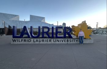 Kristabel standing in front of the Wilfrid Laurier sign