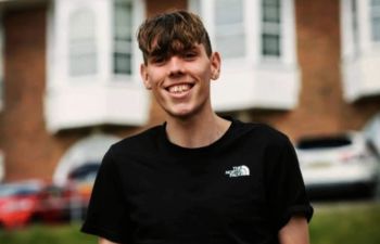 Photograph of Justin stood outside wearing a black t-shirt.
