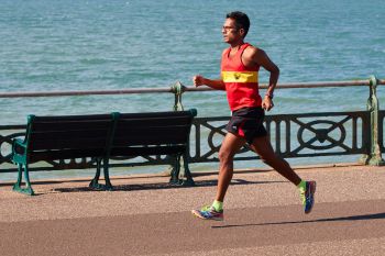 A marathon runner running along the seafront by the sea