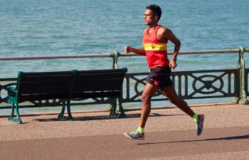 A marathon runner running along the seafront by the sea