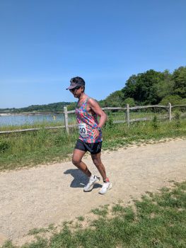 a man running by a lake on a chalk path