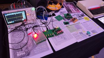 table with synthesizers and papers on it