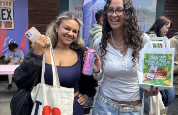 Two students holding up their free food at welcome week
