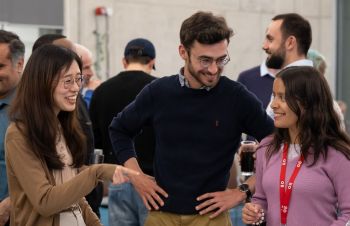 A photo of three students networking and smiling in a group setting at an Entrepreneurship event