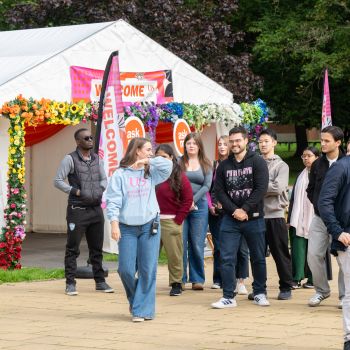 A student ambassador leading a group of students on a campus tour