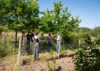 Tutor teaching students outside in the South Downs National Park surrounded by greenery, nature and blue skies