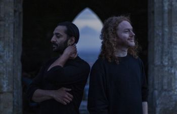 The two members of Emptyset at dusk, facing away from each other.