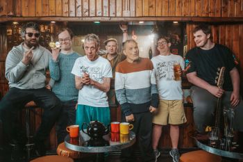 The subjects of the documentary standing in front of a pub bar.