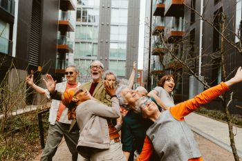A group of older people dancing together in the street.