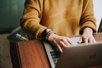 Colleague hovering hands over an open laptop