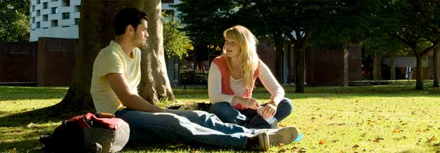 Students sitting under a tree on campus