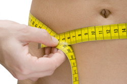 person measuring their waist
