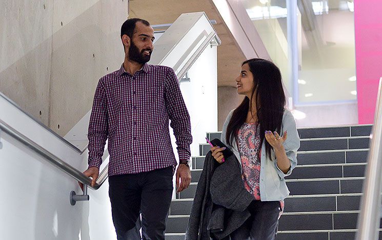 Two people in conversation on the stairs in the Jubilee atrium