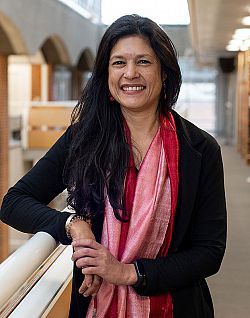 A full portrait of Rejane Woodroffe, standing in the Library