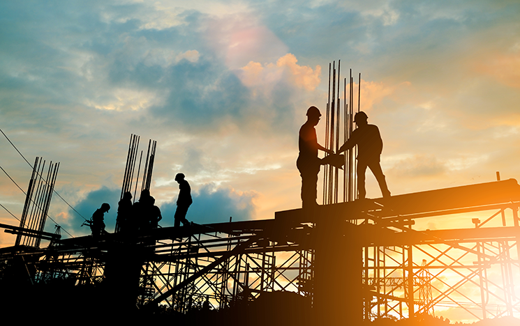 Image of construction workers at sunset
