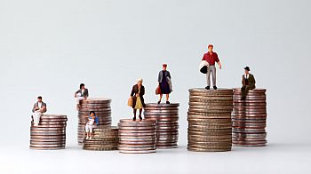 Miniature figures next to piles of coins