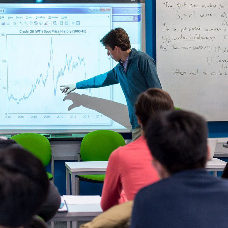 a lecturer points to data on a whiteboard