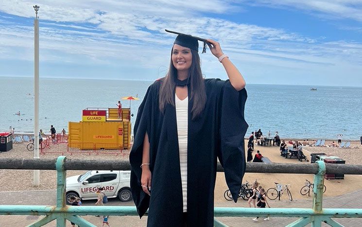 Heather McGee celebrating at Graduation in her gown