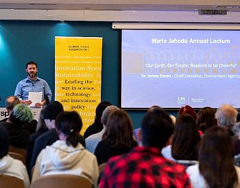 Dr Adrian Ely addresses audience from the podium at the Marie Jahoda Annual Lecture