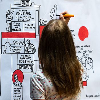 Close up of artist Raquel Durán as she works on vivid live illustration of keynote session