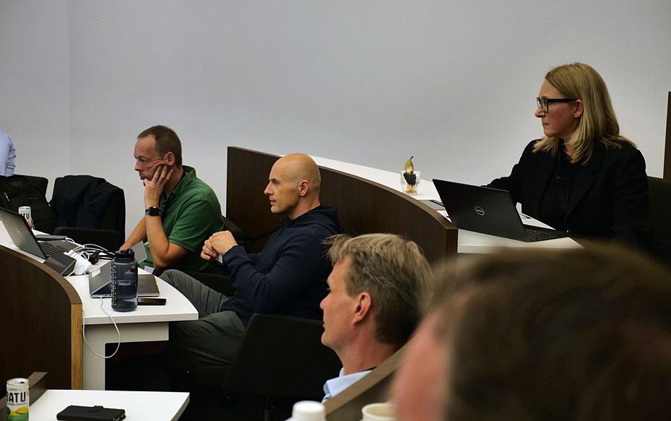 Monique Donders, the organiser from BlackRock sitting with other conference attendees and speakers watching the presentation