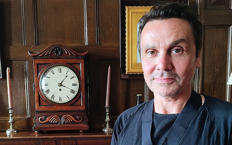 Matthew Bird, Mayor of Lewes stood in front of a wooden clock and fireplace