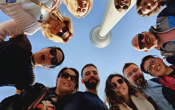 Study abroad students and staff looking into the cameral lens from above in a circle smiling