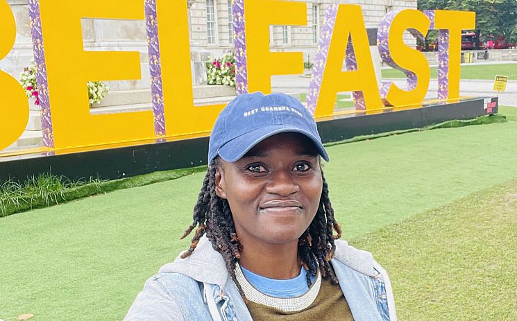 Eunice Shapange stood in front of 'Belfast' sign