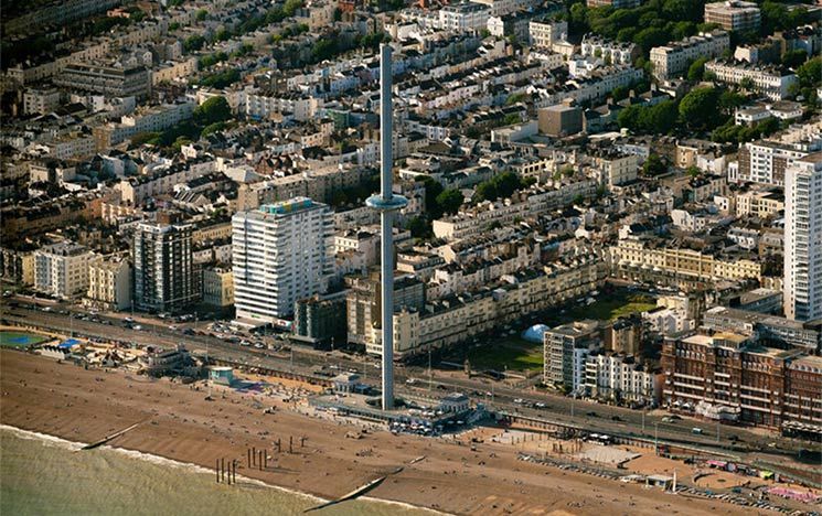 Brighton beach on a sunny day with the i360 and city buildings in the background