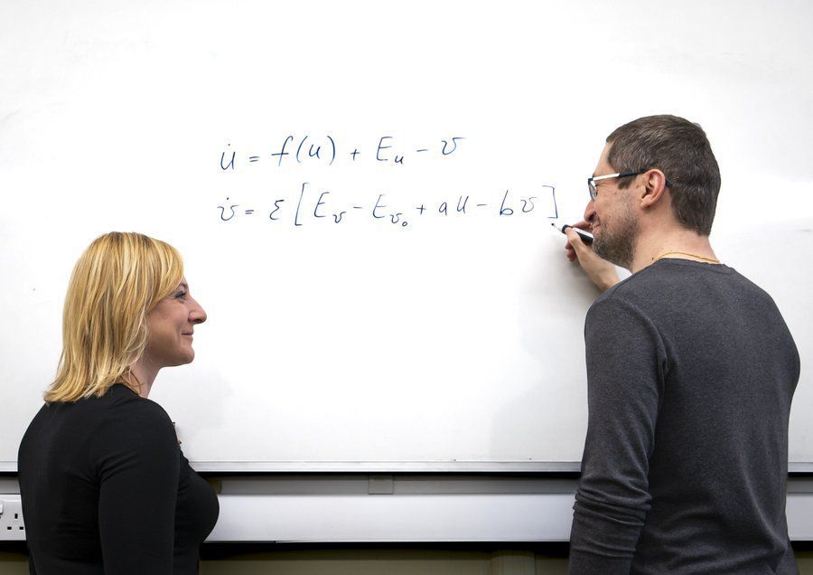 male and female in front of a whiteboard