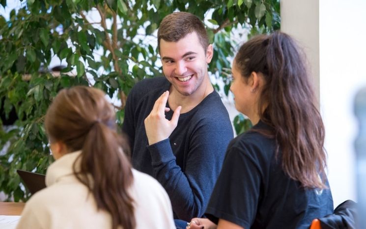 Three psychology students laughing during a seminar