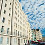 Photo of the front of the University building on Kings Road, an eight storey, grand, white building on Brighton seafront.