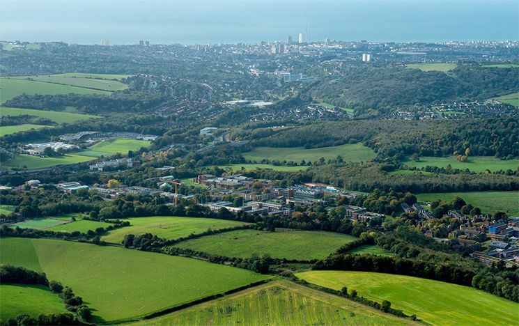 Aerial shot of campus with the ocean in view in the background.