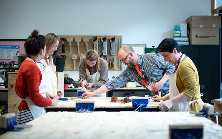 Trainee teachers working at a bench in a workshop