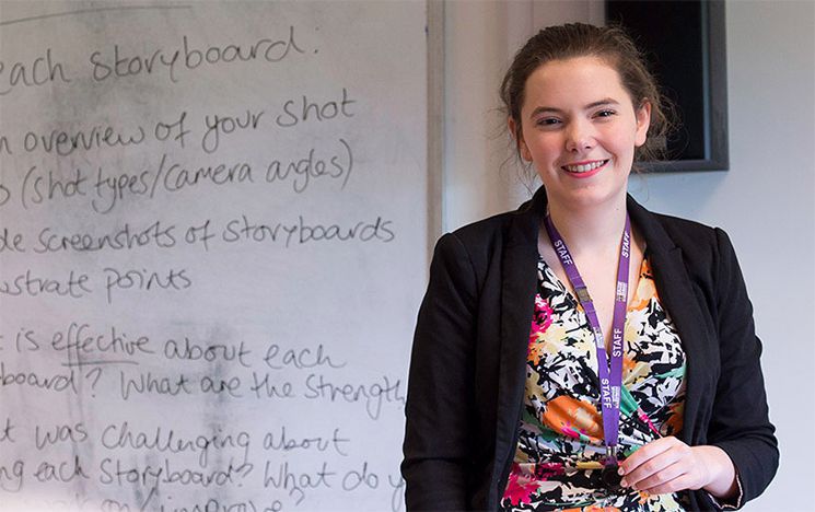 Smiling teacher in front of a whiteboard