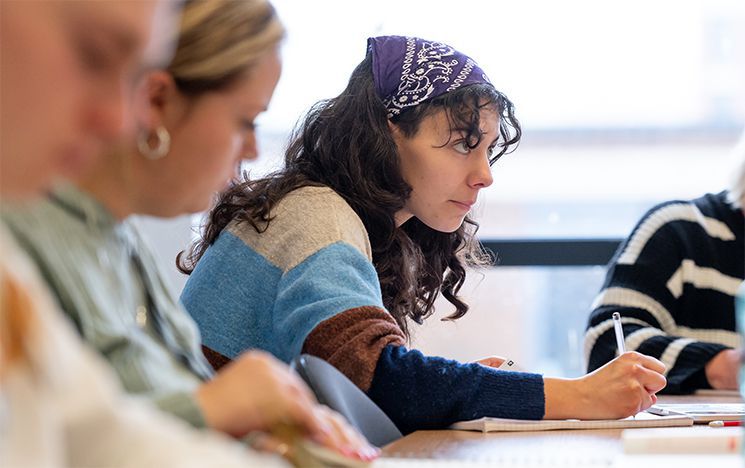 Student taking notes during an Arabic language course