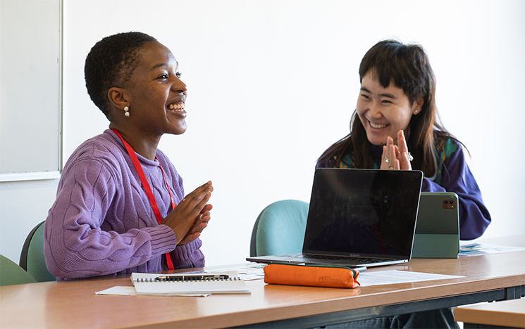 Two students laughing during a German language class