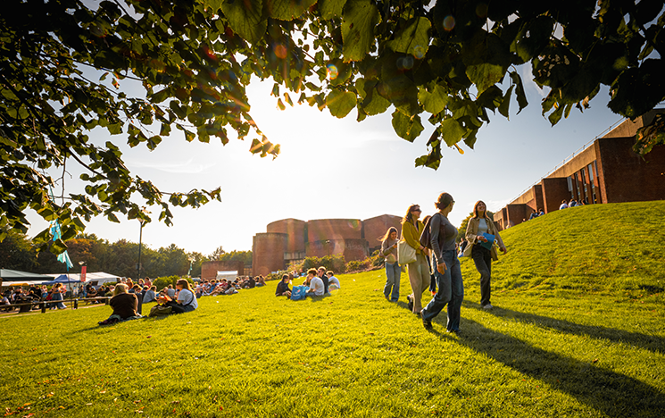 Students walking across campus lawns outside the library