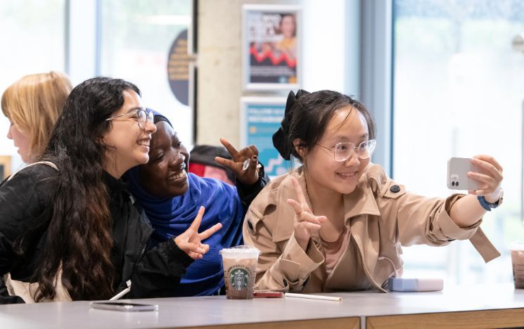 Summer School students take a selfie in a cafe on campus