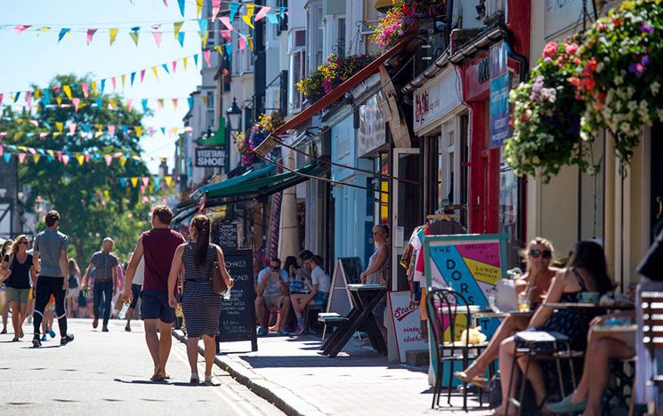 People sitting outside cafes and walking down the street