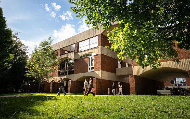 Students walking by red brick building