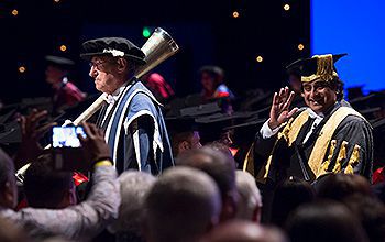 Academic staff file from the stage at a graduation ceremony