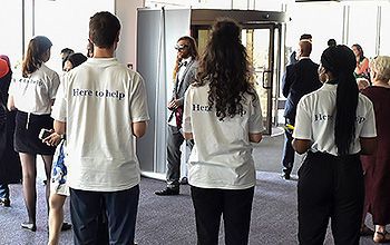 Staff greeting graduands and guests as they enter the Brighton Centre